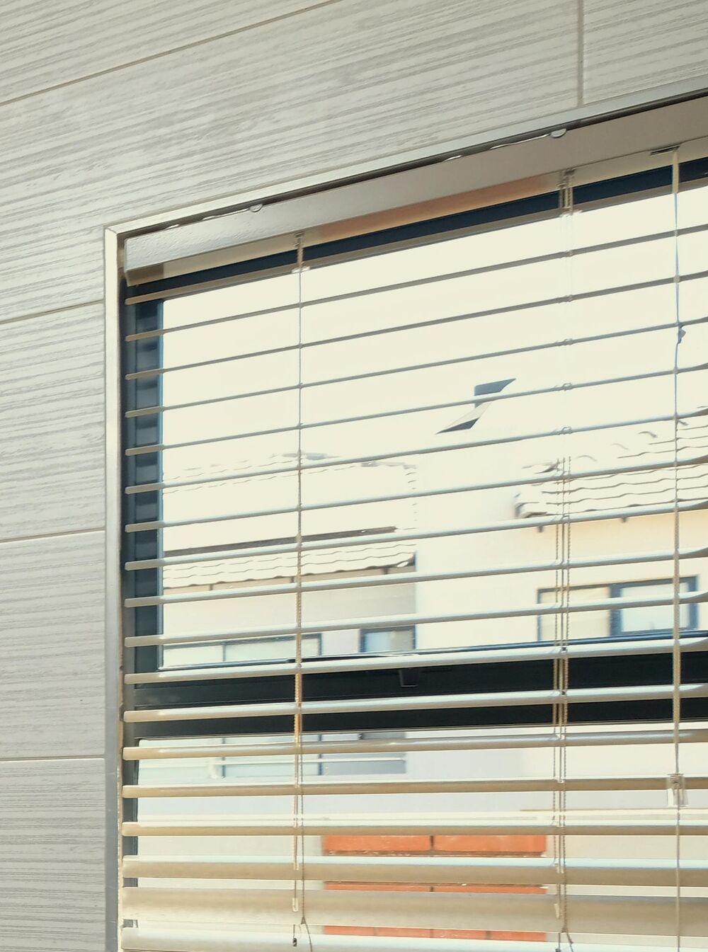Close-up of light venetian blinds fitted to a window