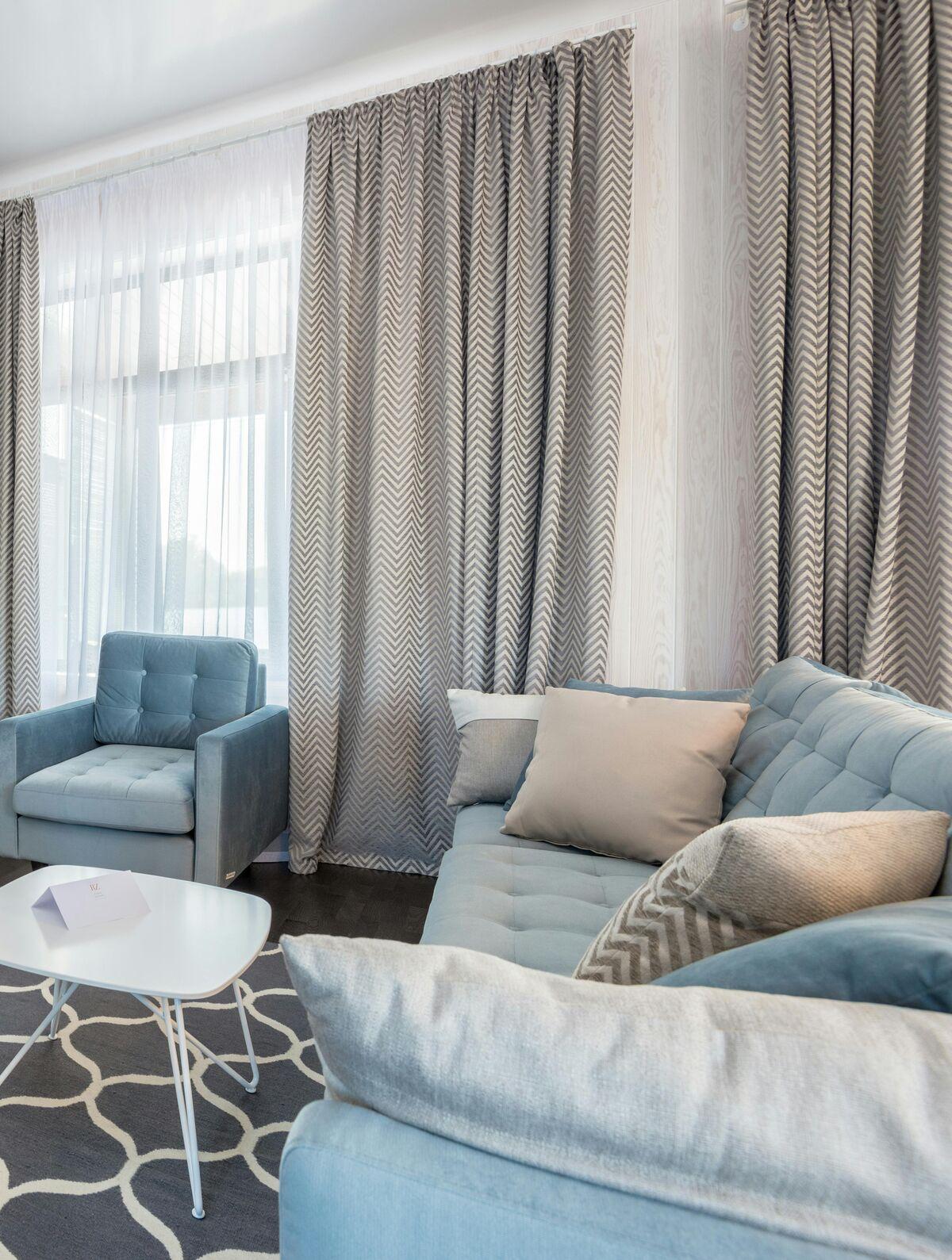Floor-length grey chevron curtains layered over white sheers in a bright living room