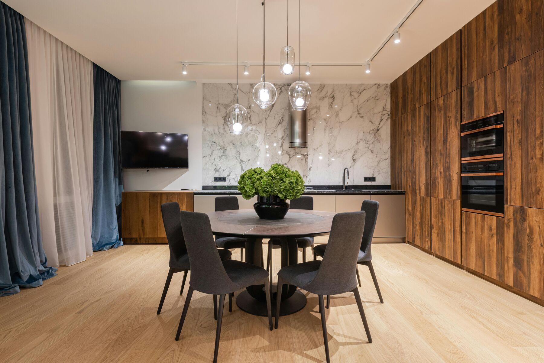 Dining area framed by deep blue velvet curtains over white sheers
