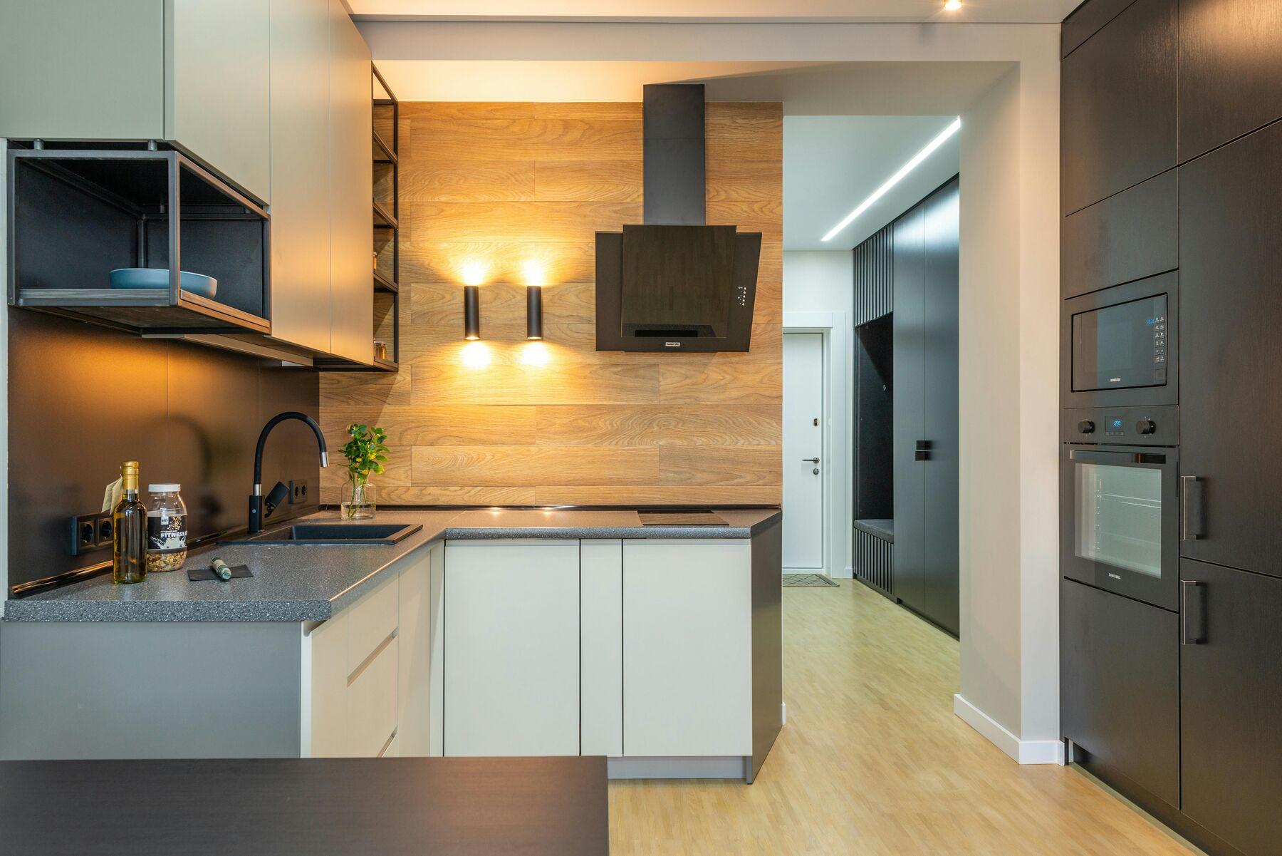 Kitchen with warm wall lights over a wood-panel backsplash